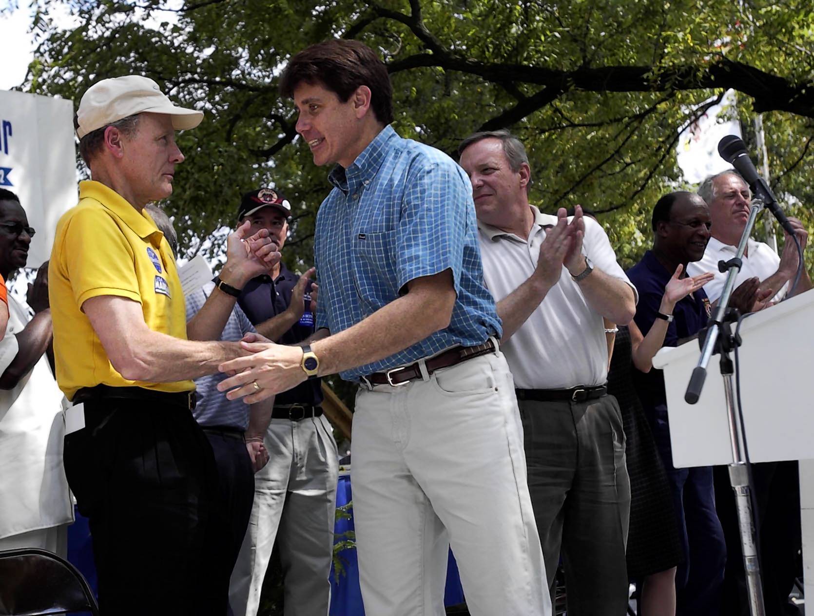 Rod Blagojevich, center, shakes hands with Michael Madigan after his...